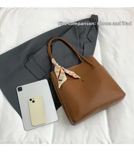 Brown lychee leather bucket bag with silk scarf showing size comparison with iPad