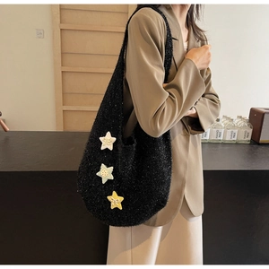 Detail einer schwarzen flauschigen Schultertasche mit Glitzer und bunten Sternen