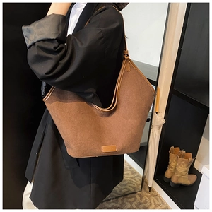 Braune Wildleder-Einkaufstasche am Model mit großer Hobo-Form und geräumigem Design