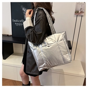 Sac fourre-tout argenté matelassé avec finition métallique porté par un mannequin