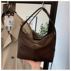 Detailed view of dark brown faux leather hobo bag with silver zipper and adjustable strap