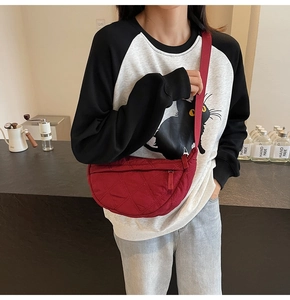 Detail of red quilted dumpling bag showing the stylish texture and adjustable shoulder strap