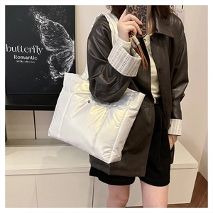 Détail du sac cabas matelassé blanc avec bouton-pression en argent et bandoulière