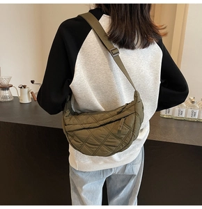 Model view of army green quilted half-moon bag with adjustable fabric shoulder strap