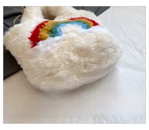 Close-up of rainbow pattern on white plush handbag with gold metal chain strap detail