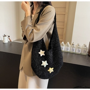 Detail der schwarzen Strick-Hobo-Tasche mit bunten Sternen-Patches und Schleifen