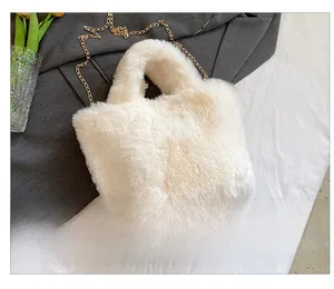 Detail view of cream white plush handbag featuring a fine golden metal chain strap