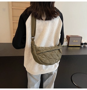 Detail of army green quilted crescent bag showing large capacity and soft nylon texture