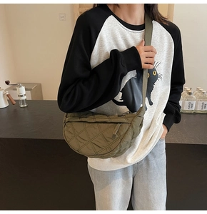 Detailed shot of olive green quilted dumpling bag with adjustable wide shoulder strap