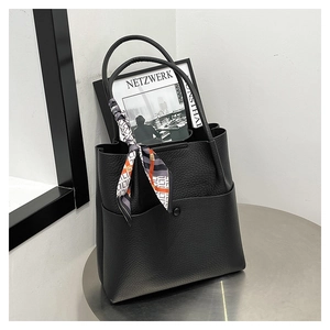 Detail of black lychee grain leather tote bag with elegant geometric print silk scarf