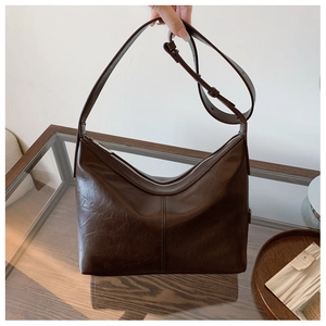 Detail of a coffee brown hobo bag showing retro oily leather texture and silver zipper