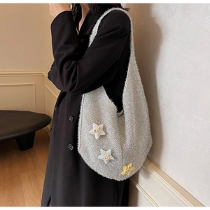 Detailansicht der silbernen Strick-Tasche mit bunten Stern-Patches und glänzendem Metallic-Garn