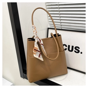 Detailed view of brown lychee texture tote bag with stylish geometric silk scarf detail