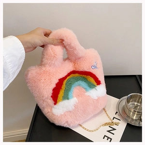 Close-up of soft pink plush handbag featuring rainbow and cloud embroidery with chain strap