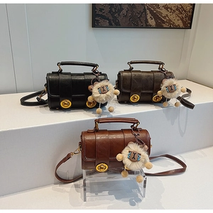 Sacs bandoulière vintage en trois coloris avec pendentifs mouton en peluche sur présentoir