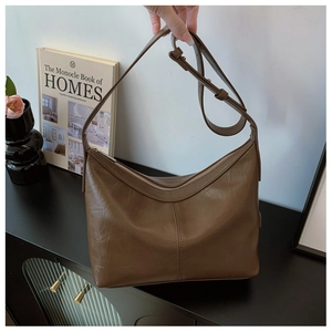Detailed view of a brown vintage leather shoulder bag with adjustable strap and zipper