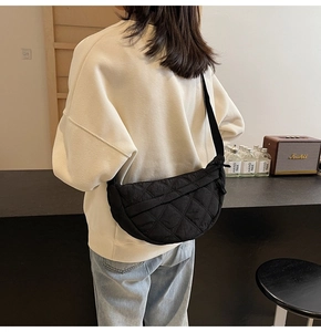 Quilted black hobo bag with a stylish crescent shape and adjustable canvas shoulder strap