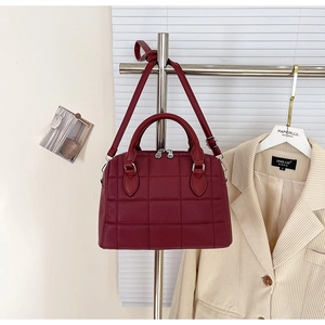 Detail showing burgundy quilted faux leather boston bag with silver hardware and dual handles