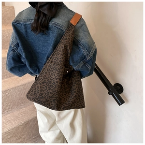 Detailed back view of a leopard print hobo tote bag with orange brown shoulder strap