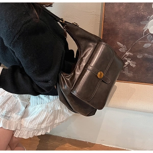 Dettaglio della borsa vintage in pelle marrone con fibbia in metallo sulla spalla