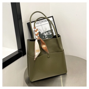 Detail of olive green bucket bag in lychee leather texture with a decorative floral scarf