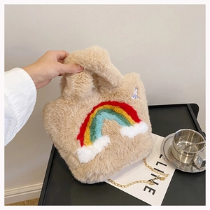 Detail of light brown faux fur handbag with rainbow embroidery and gold chain strap