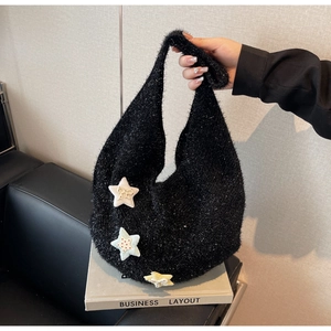 Detail der schwarzen Strick-Hobo-Tasche mit drei bunten Plüschstern-Anhängern und Metallic-Garn