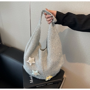 Detailansicht der silbernen Stricktasche mit Paillettenstruktur und bunten Sternen