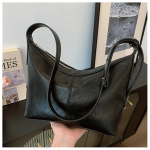 Detail of black pleated leather hobo bag with moon shape and silver metal zipper
