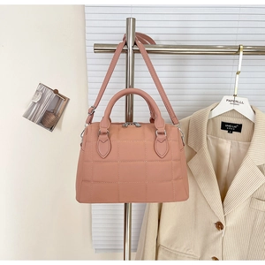 Detail of pink quilted leather tote bag with round handles and silver hardware