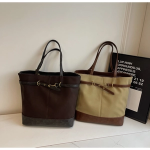Minimalist canvas tote bag with leather straps and gold buckle detail for daily travel