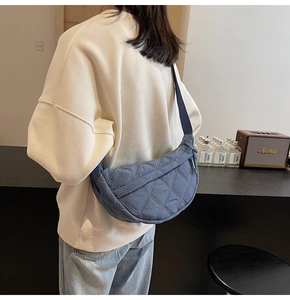 Blue quilted nylon crescent bag worn by model showing size and drape in daily scene