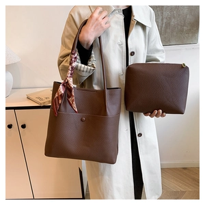 Detail of brown litchi pattern bucket bag with decorative silk scarf and matching pouch