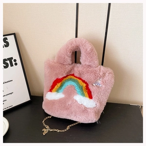 Detail of pink plush bag with rainbow embroidery, gold chain, and cute rabbit brooch