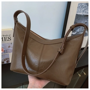 Detail of dark brown wrinkled leather shoulder bag with adjustable strap and silver zipper
