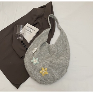 Detail der grauen Stricktasche mit glänzenden Silberfäden und sternförmigen Akzenten