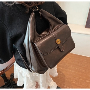 Dettaglio della borsa Hobo marrone scuro con fibbia in metallo dorato N sulla tasca