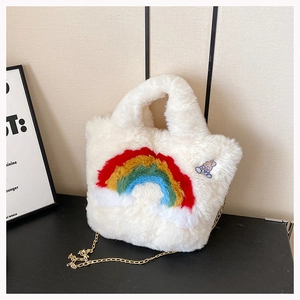 Macro shot of fluffy white plush handbag featuring rainbow embroidery and rabbit patch detail