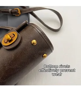 Détail du sac Boston marron montrant les rivets dorés et le cuir ciré vintage de qualité
