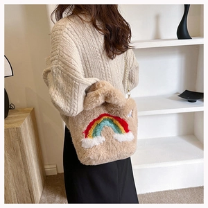 Detail of soft plush rainbow handbag with embroidery and cloud decoration in camel fur