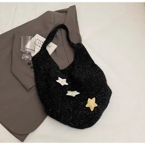 Detailansicht der schwarzen Plüsch-Stricktasche mit bunten Stern-Patches und Schleifen