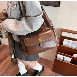 Dettaglio borsa vintage marrone con fibbia decorativa in metallo dorato N