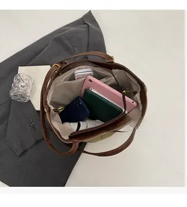 Macro view of multi-compartment interior for khaki tote bag showing large storage capacity