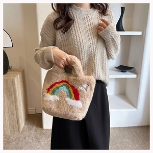 Detail of plush tote bag with rainbow embroidery and white bunny emblem on soft beige fur