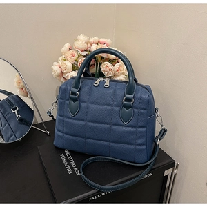 Detail of navy blue quilted Boston bag with litchi texture and silver hardware