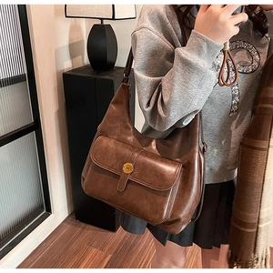 Dettaglio della borsa hobo vintage marrone scuro con fibbia a N in bronzo in un selfie