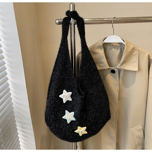 Detailaufnahme der schwarzen Plüschtasche mit bunten Sternen und Mini-Schleifen-Details