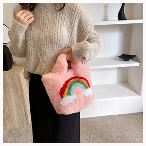 Detailed close-up of a soft pink plush crossbody bag with rainbow and cloud embroidery