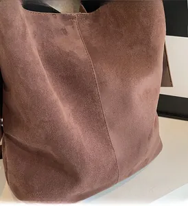 Close-up of retro brown faux suede tote bag featuring detailed side stitching and texture