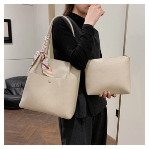 Detail of cream white bucket bag set with pebble leather texture and silk scarf detail